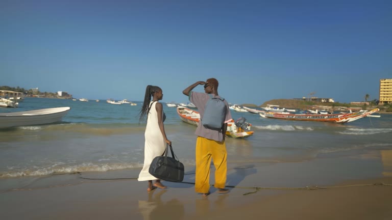 Travelers pause with Away luggage on a Dakar beach
